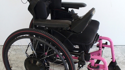 Persona en silla de ruedas ajustando los reposabrazos de su nueva silla de ruedas, encontrando comodidad y adaptabilidad